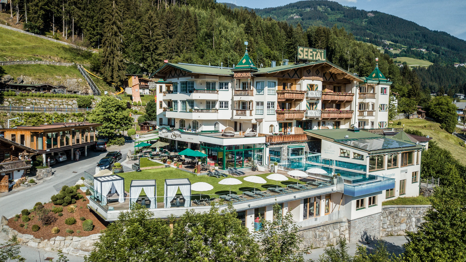 Hotelanlage mit Außenpool und Sonnenterrasse in Hanglage.
