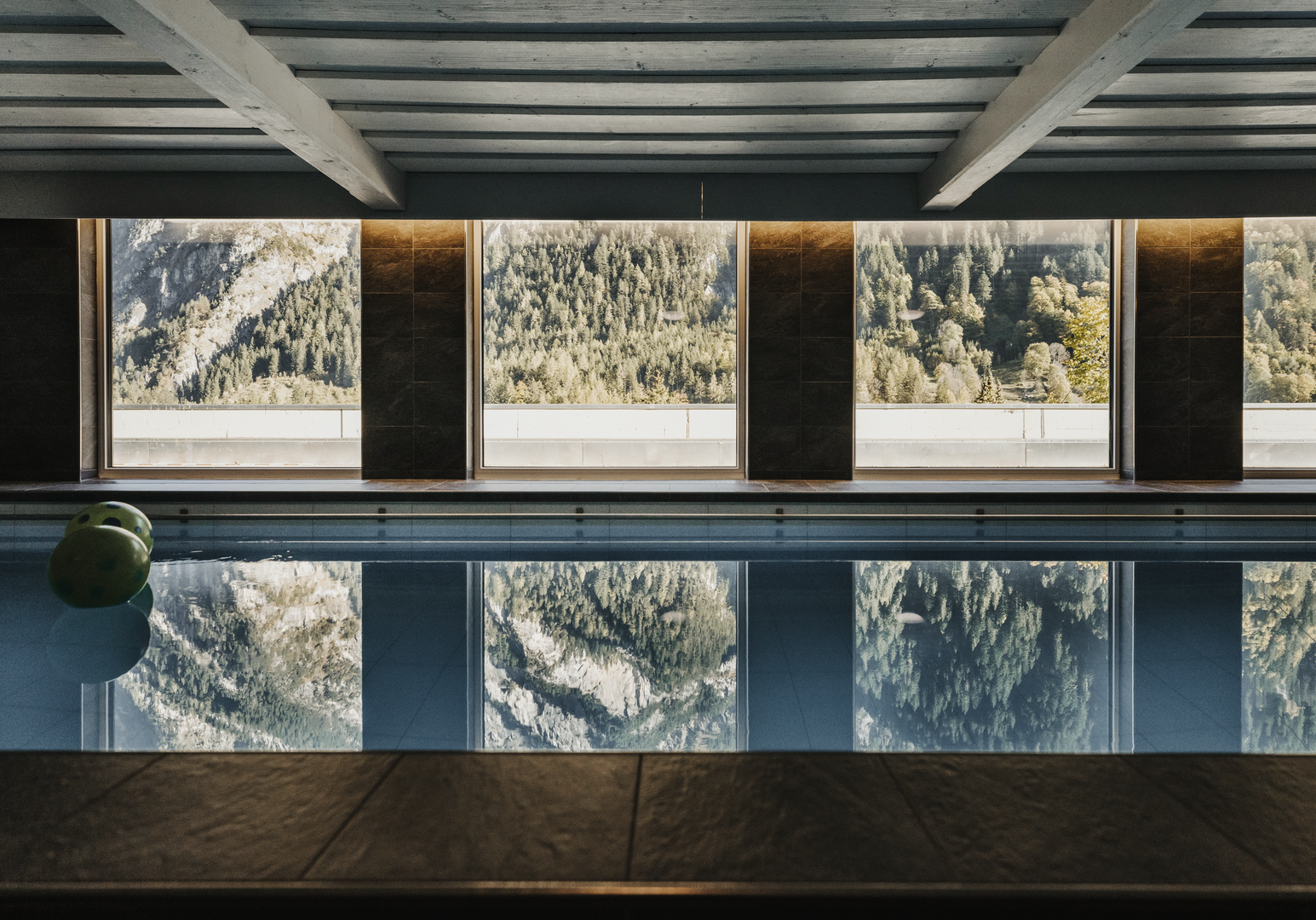 Innenpool mit großen Fensterfronten und Blick auf die winterliche Landschaft.