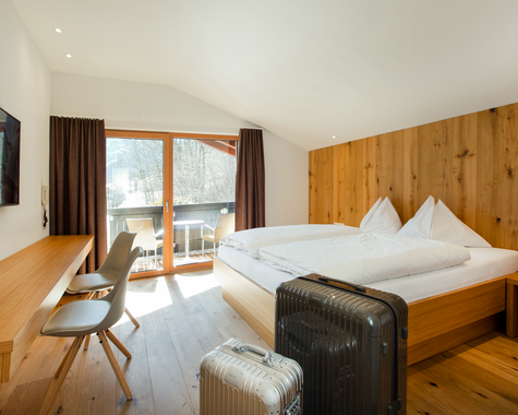 Schlafzimmer mit Doppelbett und Balkon, TV und Schreibtisch