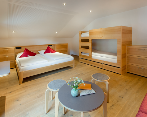 Zimmer mit Doppelbett, Etagenbett und Sitzbereich