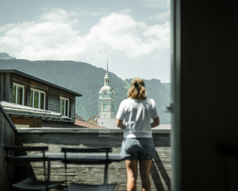Frau steht auf einem Balkon und genießt die Aussicht 