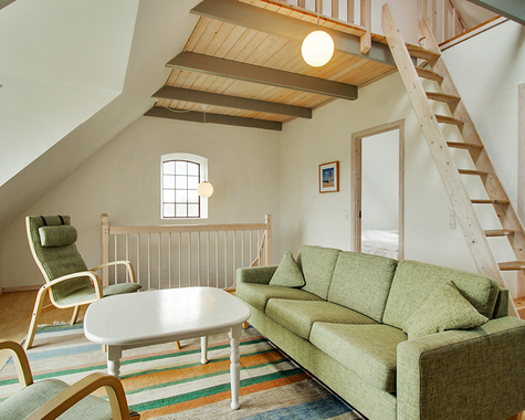 Wohnbereich mit Sofa und Treppe zur Galerie