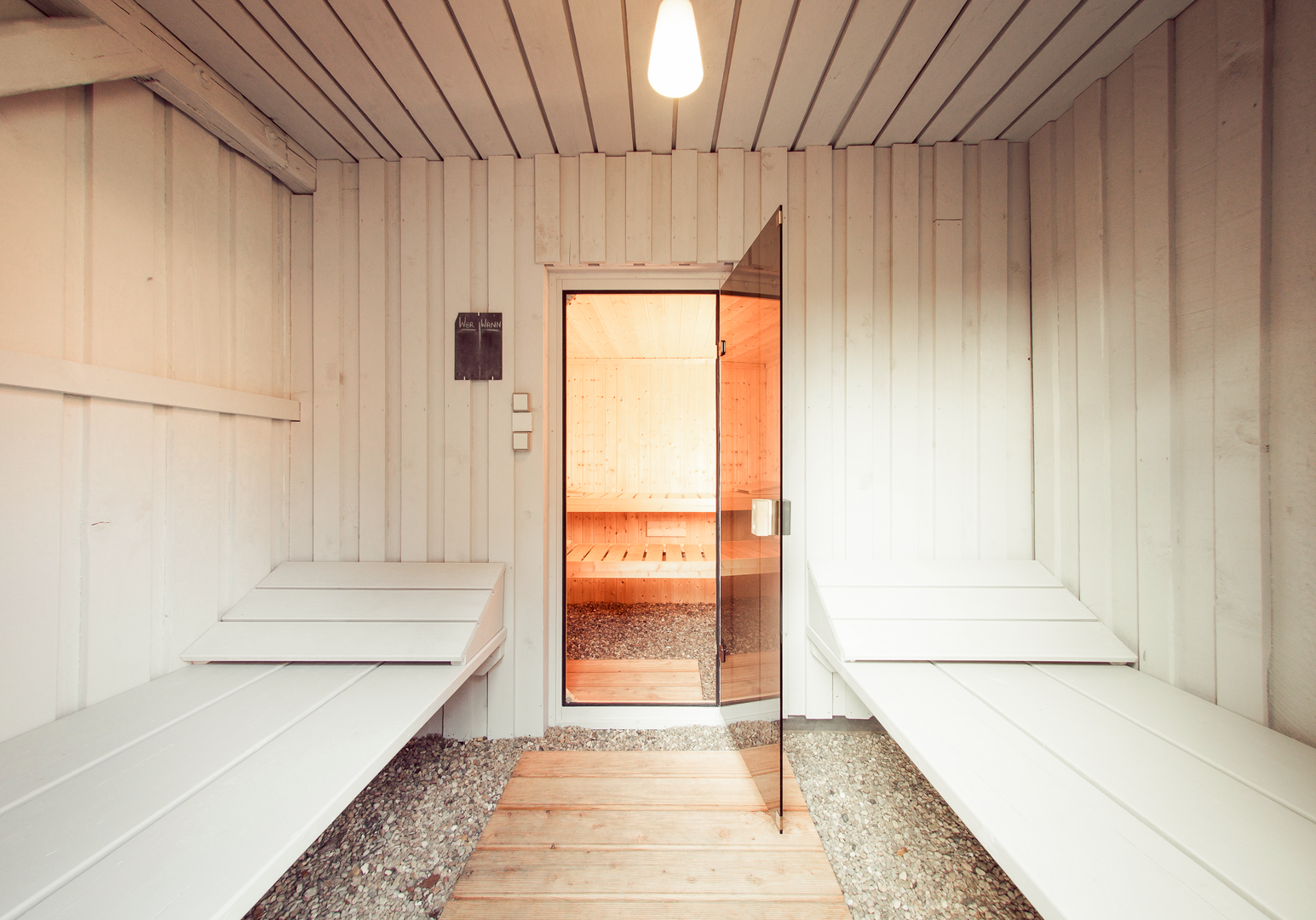 Sauna mit Holzbänken und geöffneter Tür