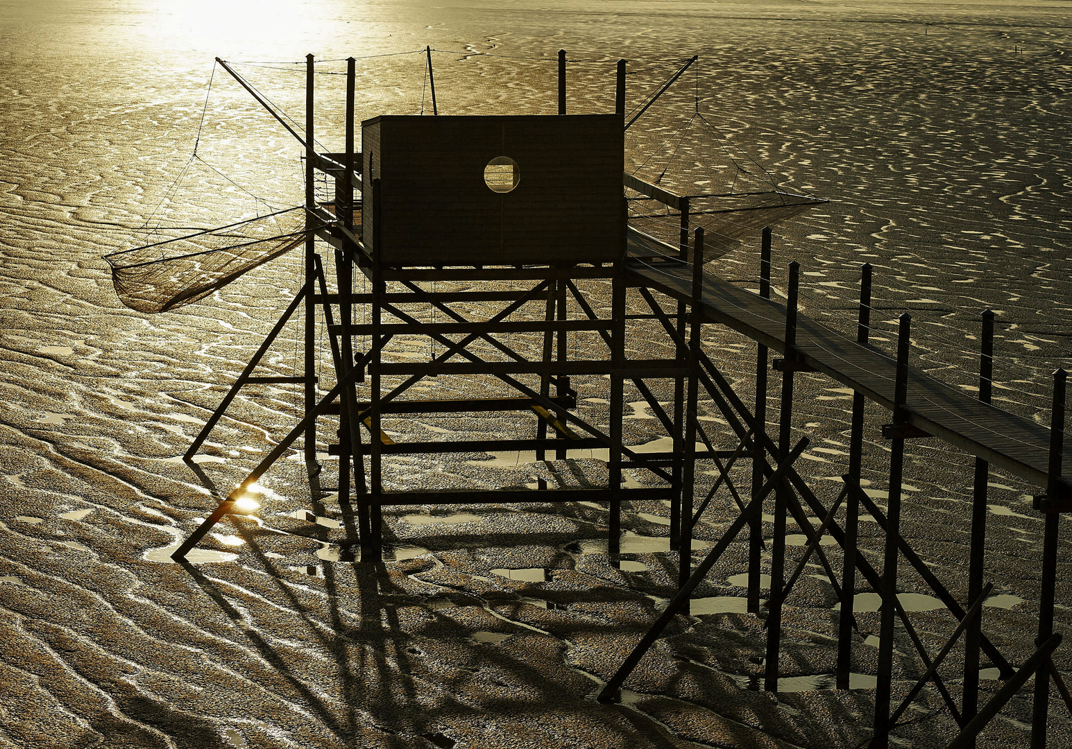 Holzsteg oder Plattform im Wasser, beleuchtet von tief stehender Sonne