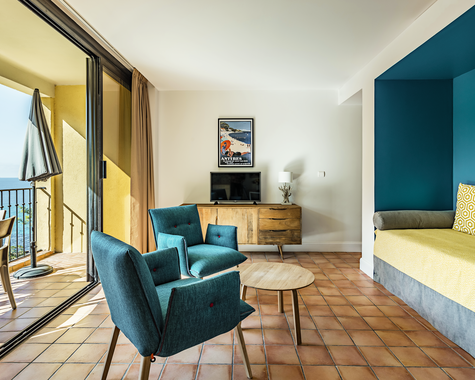 Wohnzimmer mit türkisen Sesseln, Sofa und Meerblick