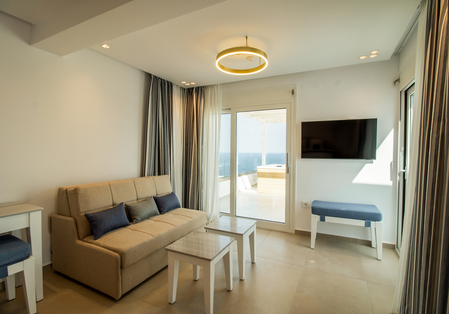 Wohnbereich mit Sofa, TV und Zugang zur Terrasse