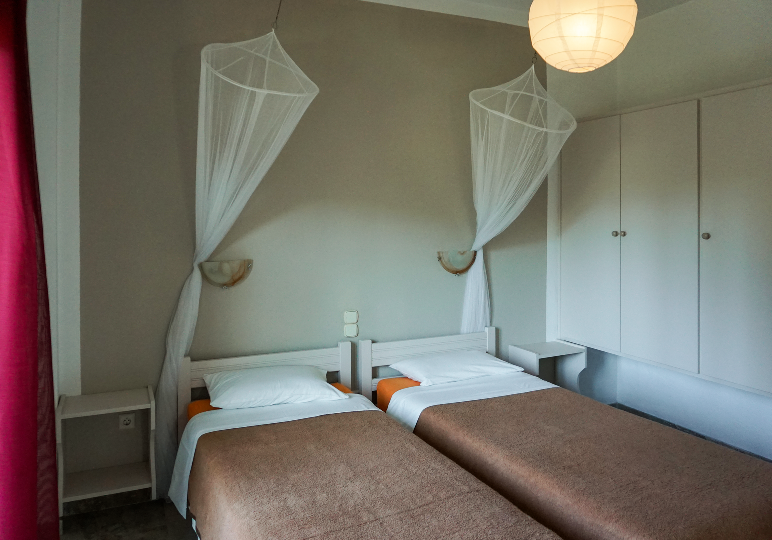 Schlafzimmer mit Einzelbetten und Moskitonetz