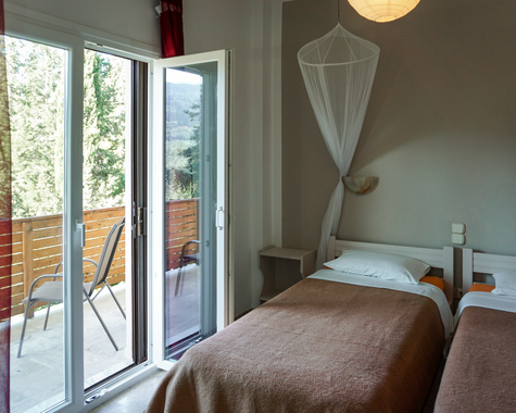 Schlafzimmer mit Einzelbetten und Balkonzugang