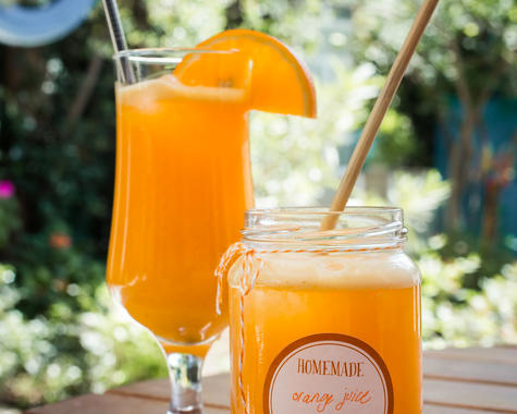 Frischer Orangensaft im Glas auf sonniger Terrasse