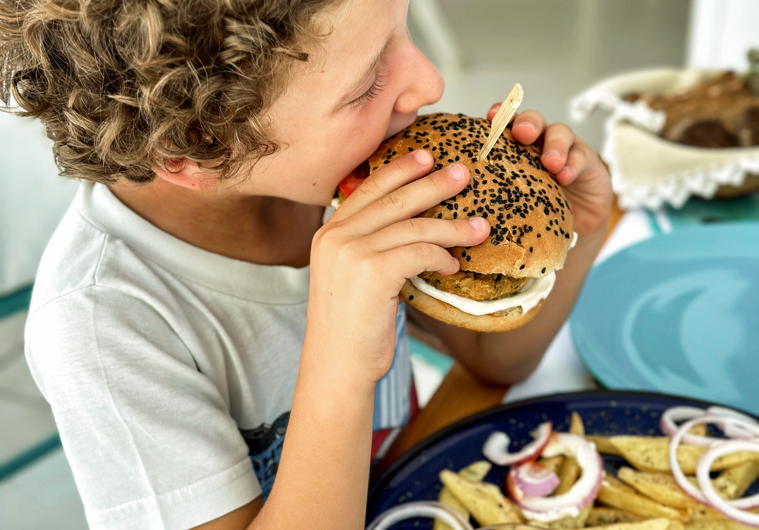 Kind genießt einen Burger mit Pommes 