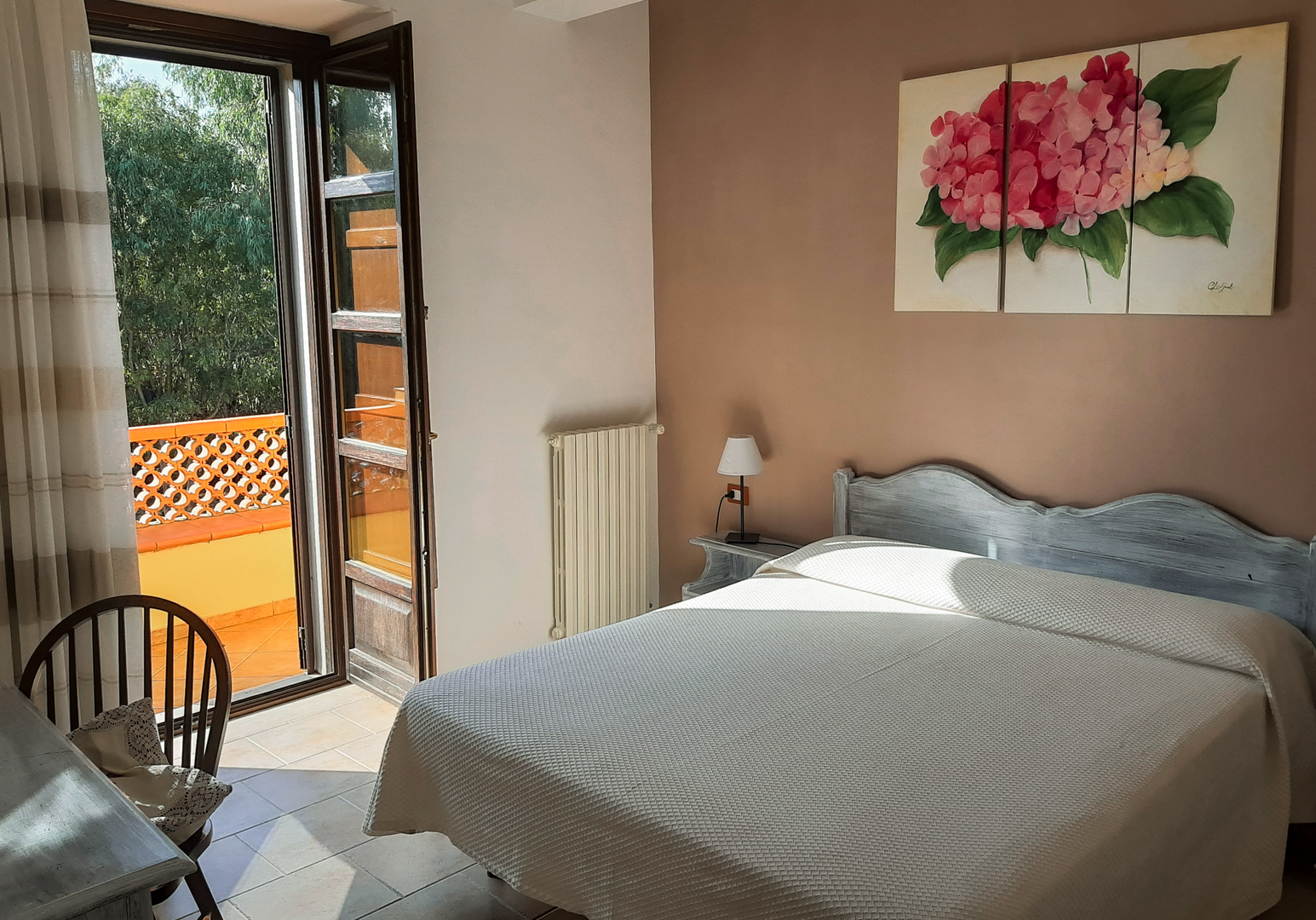 Schlafzimmer mit Doppelbett und Zugang zum Balkon