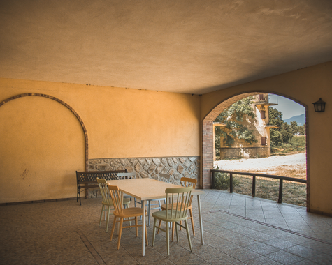 Überdachte Terrasse mit Esstisch und Rundbogen