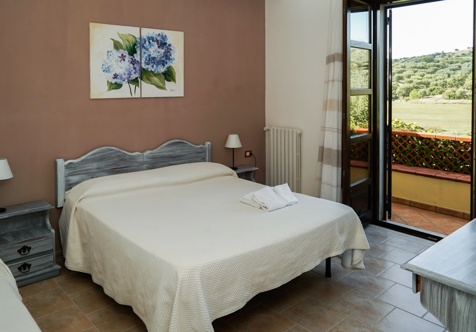 Schlafzimmer mit Doppelbett und Balkonzugang