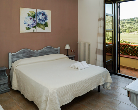 Schlafzimmer mit Doppelbett und Balkonzugang