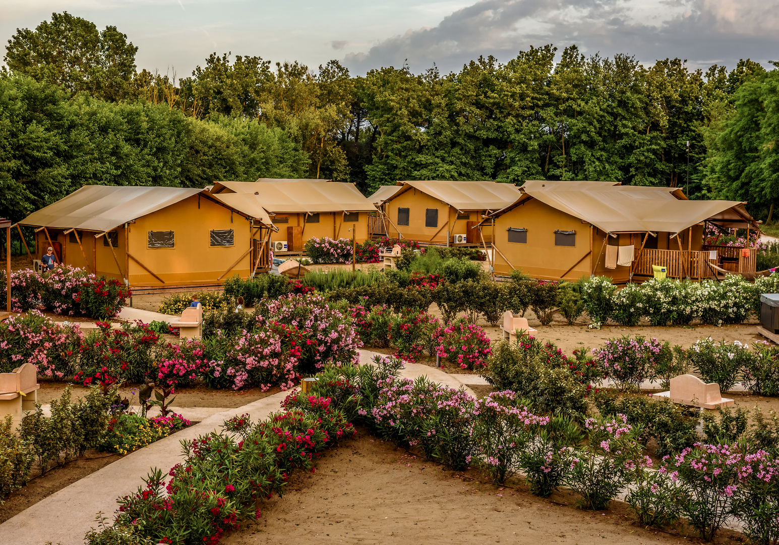 Ferienanlage mit Bungalows, blühenden Gärten und großzügigen Grünflächen.
