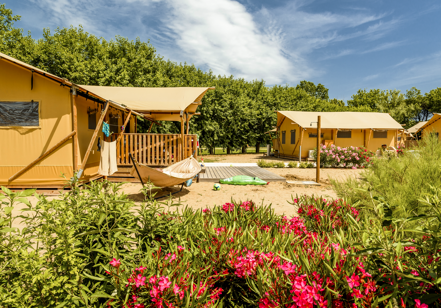Ferienunterkünfte mit Terrassen, umgeben von Blumen und mediterraner Vegetation.