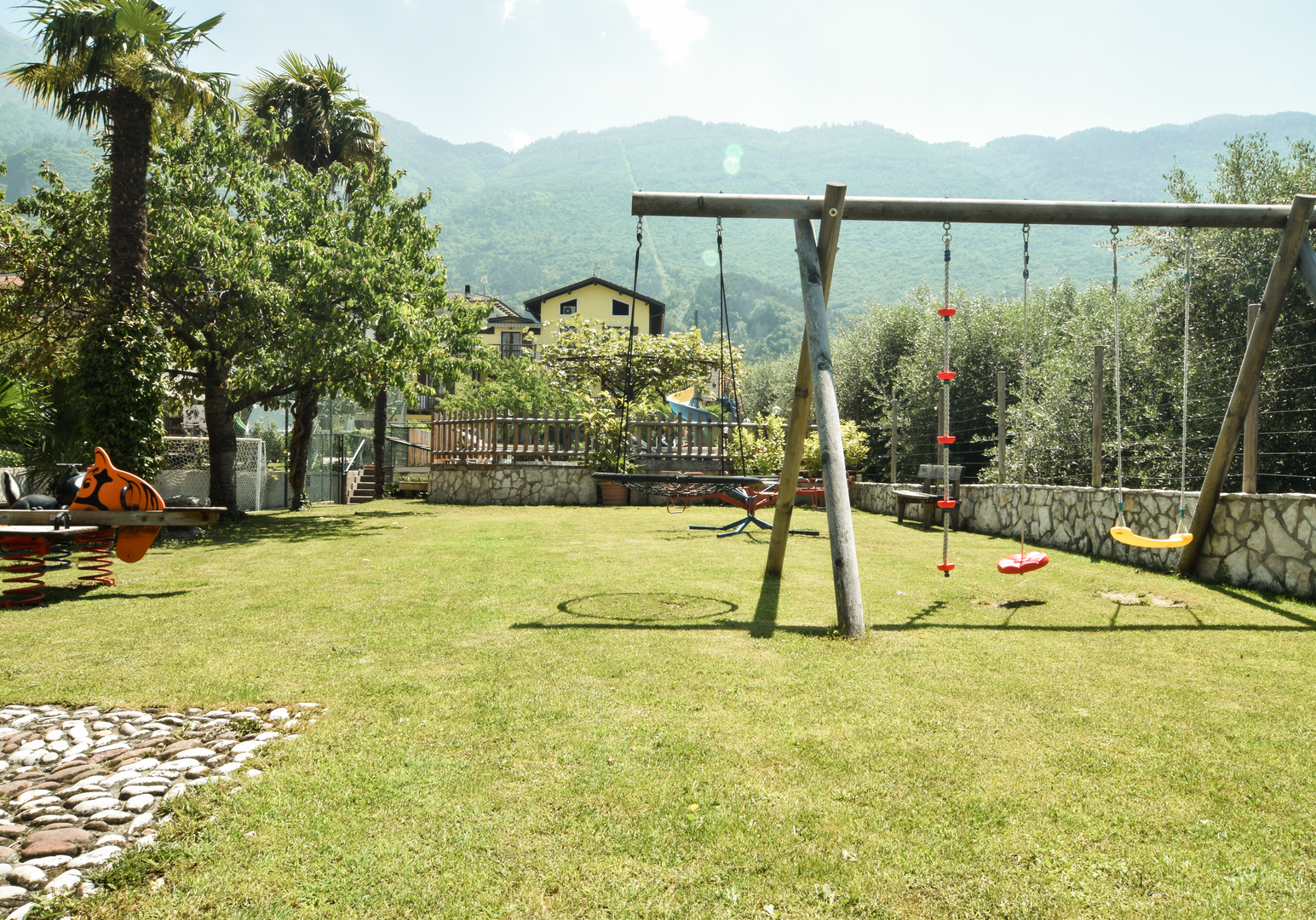Spielplatz auf einer Wiese mit Blick auf die Berge.