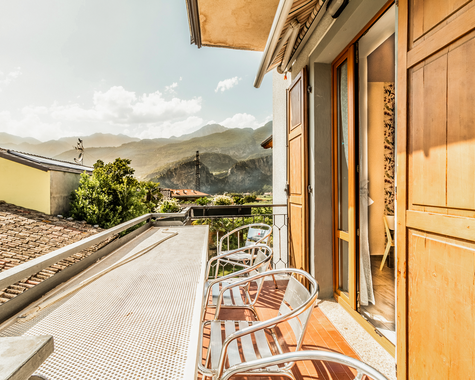 Balkon mit Sitzmöbeln und Blick auf Berge und Dächer