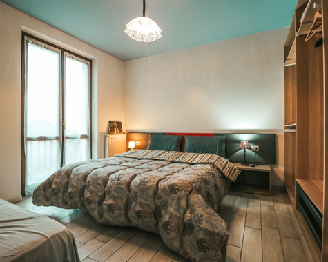 Schlafzimmer mit Doppelbett und großem Fenster