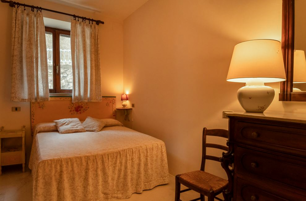 Schlafzimmer mit Doppelbett und Nachttischlampe