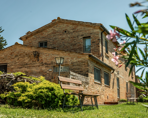 Restauriertes Landhaus aus Naturstein, umgeben von Garten und mediterranen Pflanzen.