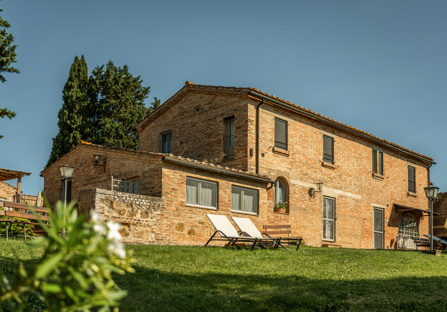 Traditionelles Landhaus mit Terrasse und Liegestühlen, eingebettet in die mediterrane Natur.