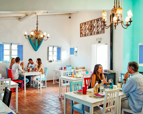 Heller Restaurantbereich mit türkisfarbenen Wänden und Sitzgelegenheiten.