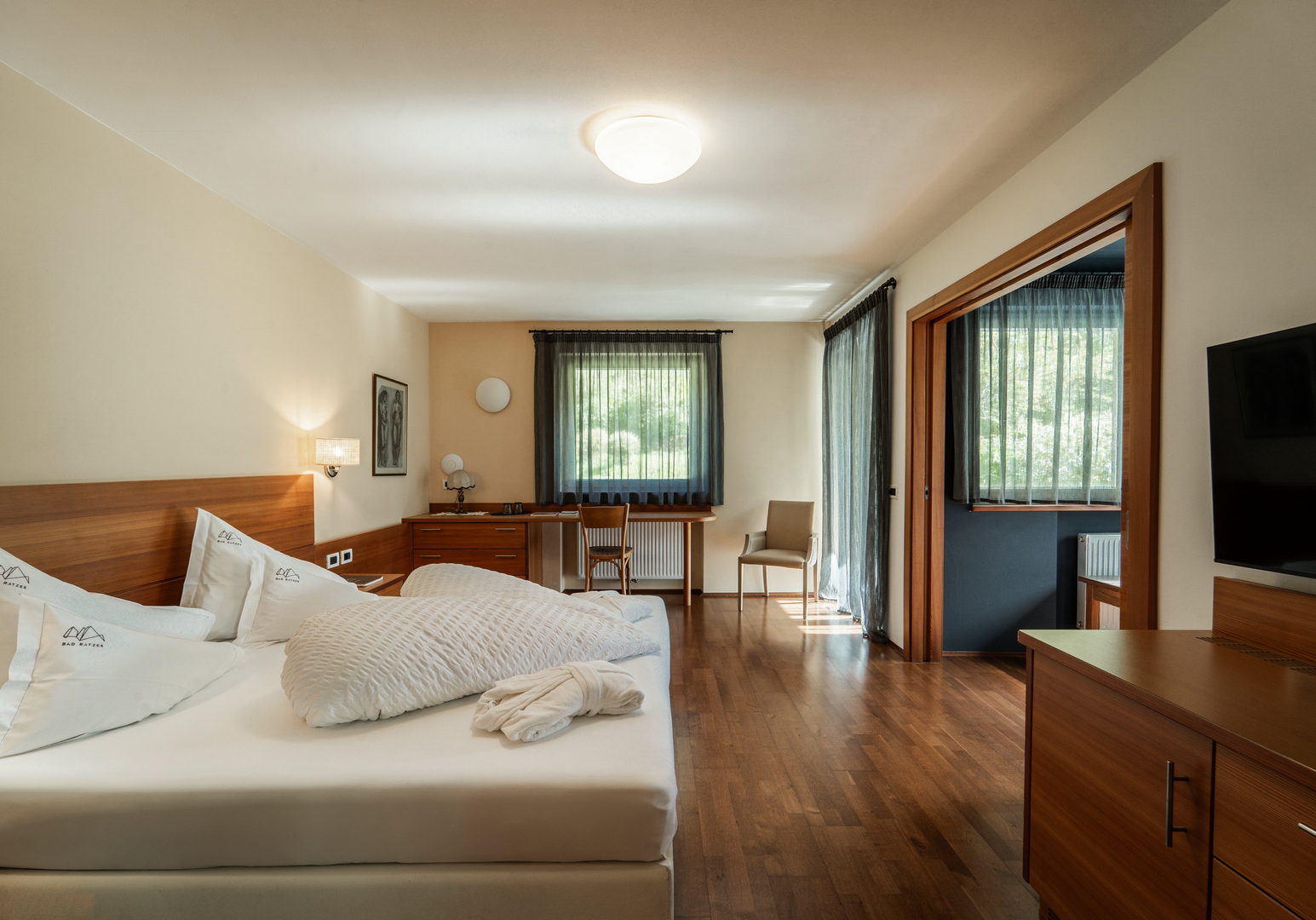 Zimmer mit Doppelbett, Schrankwand und großer Durchgangstür zum Kinderzimmer