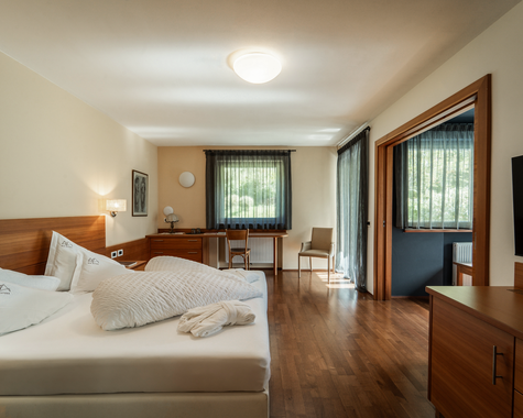 Zimmer mit Doppelbett, Schrankwand und großer Durchgangstür zum Kinderzimmer