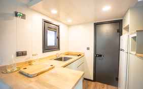 Die Küchenzeile und die Tür zum Schlafzimmer im Tiny House.