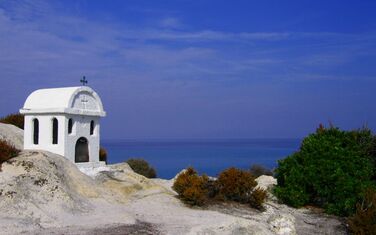 Familienurlaub in Griechenland: Meeresblick mit einer kleinen Kathedrale im Vordergrund
