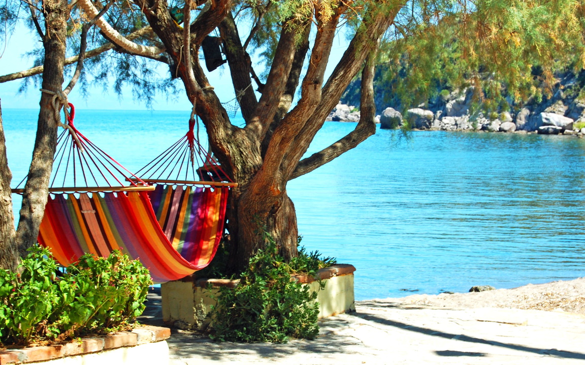 Hängeliege mit Ausblick auf das Türkis schimmernde Meer