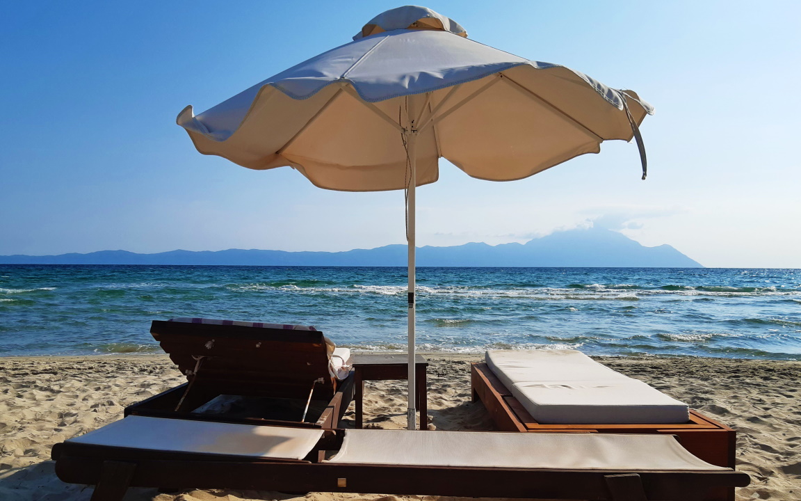 Sonnenbestrahlte Liegen am Strand