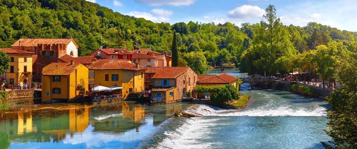 Blick auf ein Dorf am Fluss Mincio in der Nähe des Gardasees